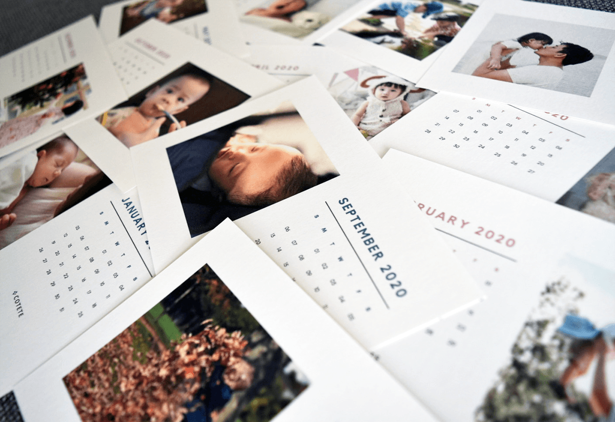 赤ちゃんや家族の写真で作ったCOTETE Calendarのフォトカレンダーが何か月分も並んでいる様子